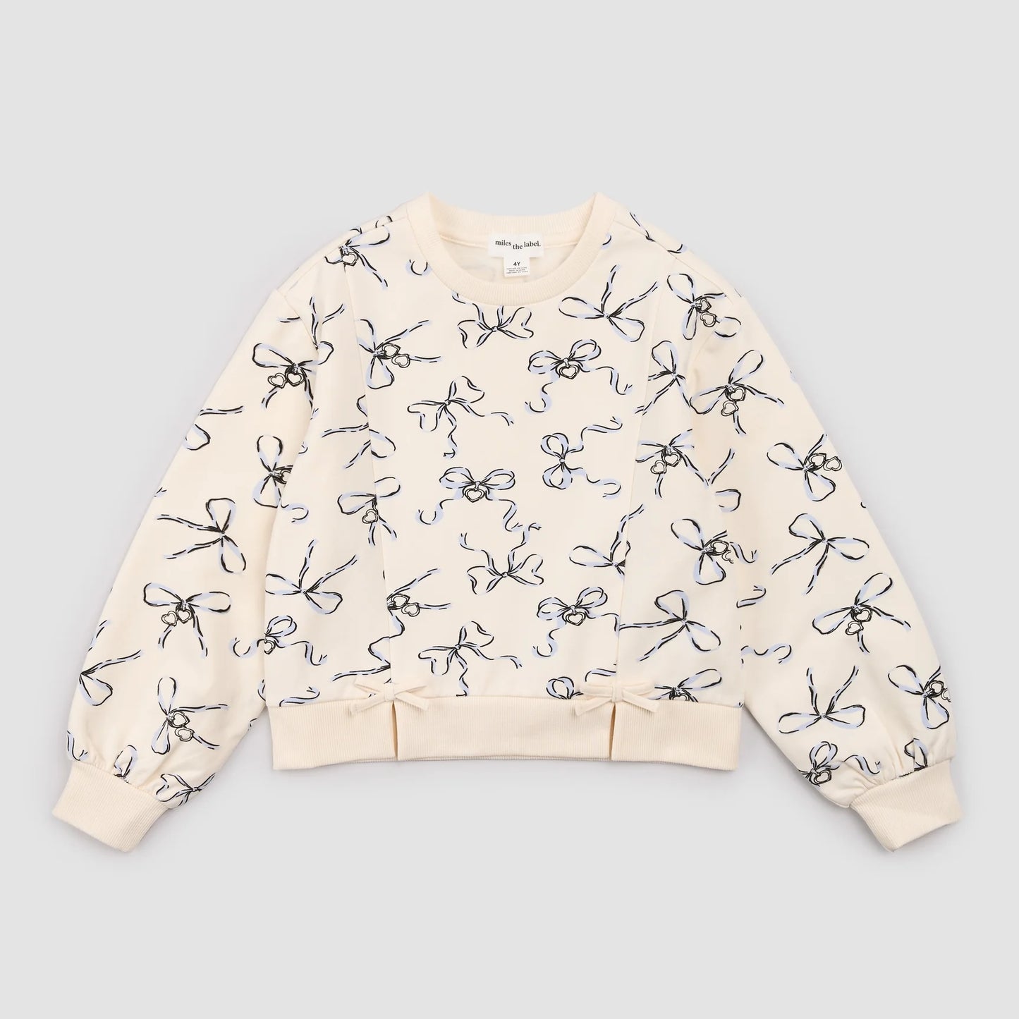 Ivory sweatshirt with bows and lockets by Miles the Label, featuring a cozy fit and decorative details in a close-up shot.
