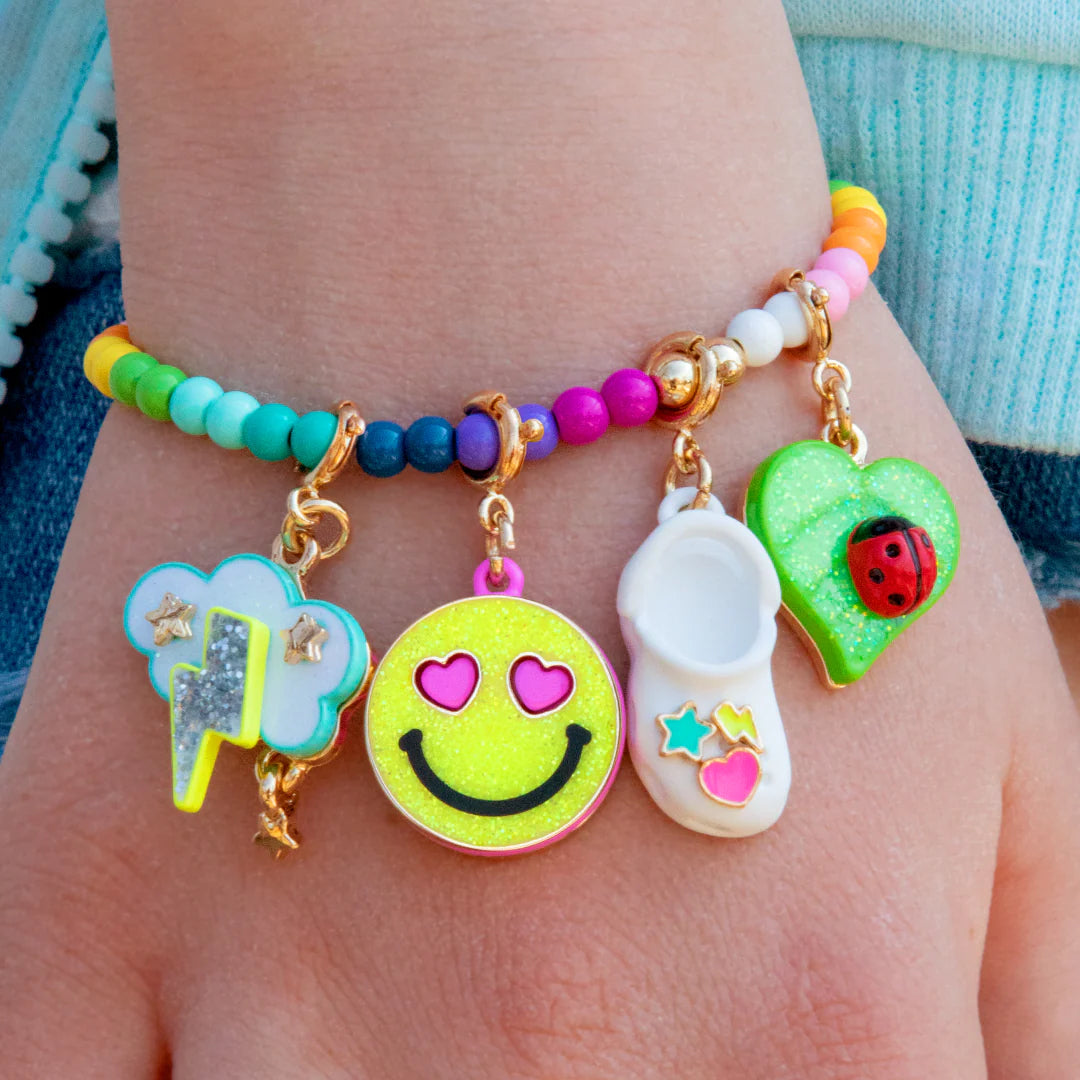 Gold glitter smiley face charm from Charm It! with a shiny, sparkling surface and playful facial features on a jewelry charm.