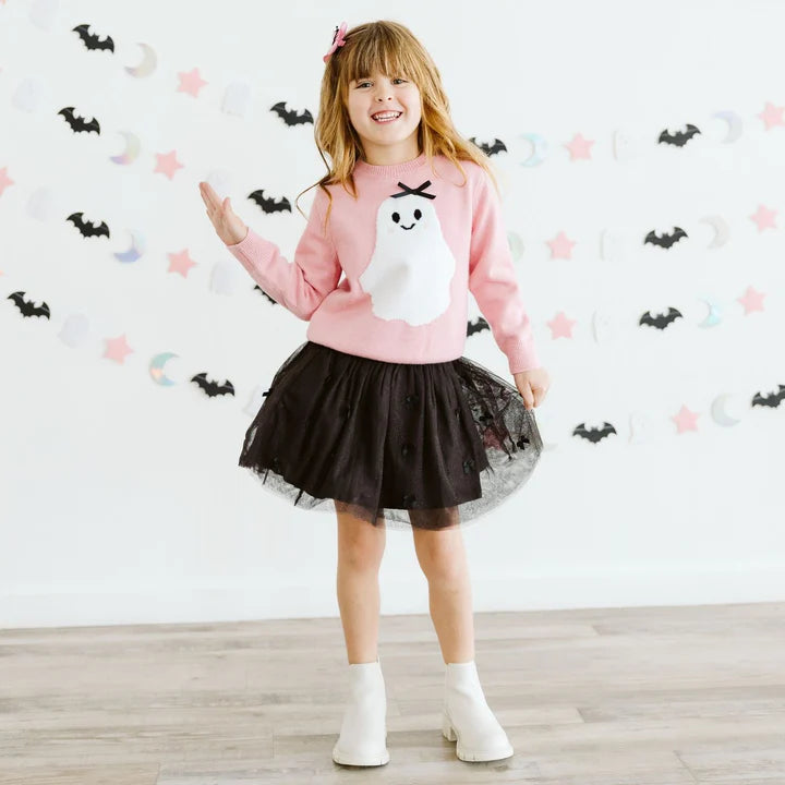 Model wearing Sweet Wink Sweet Ghost Halloween sweater with a black bow and tutu skirt, featuring festive ghost and Halloween-themed details.
