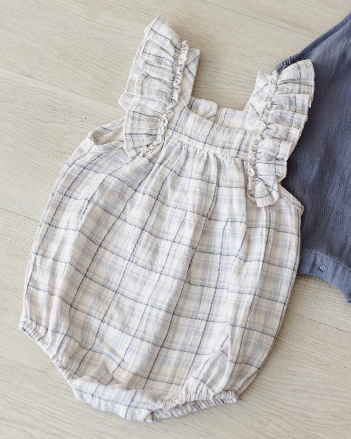 Blue plaid Quincy Mae Maya romper displayed on a child, featuring soft fabric and comfortable fit in a casual lifestyle setting.