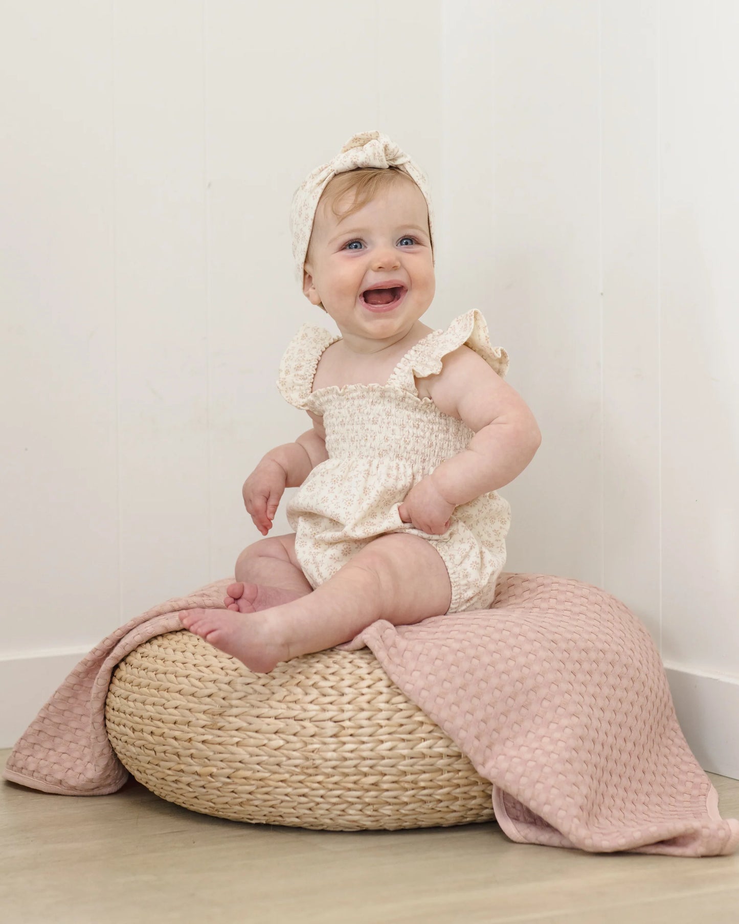 Quincy Mae Ditsy Smocked Ruffle Sleeve Romper worn by a child, showing floral print, smocked bodice, and ruffled short sleeves.