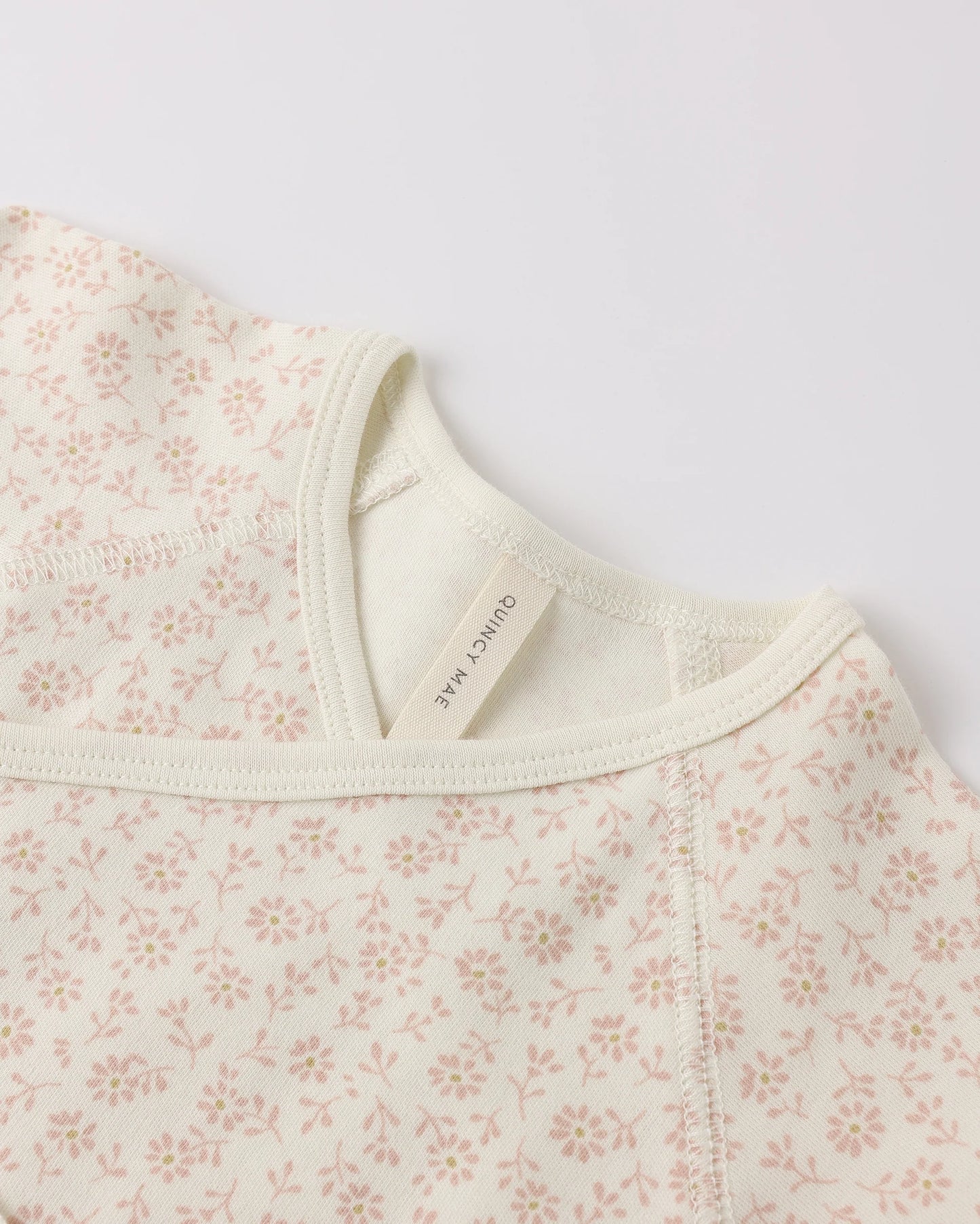 Quincy Mae Ditsy Wrap Top and Footed Pant set for babies, featuring a soft ivory fabric with delicate ditsy print and comfortable fit.