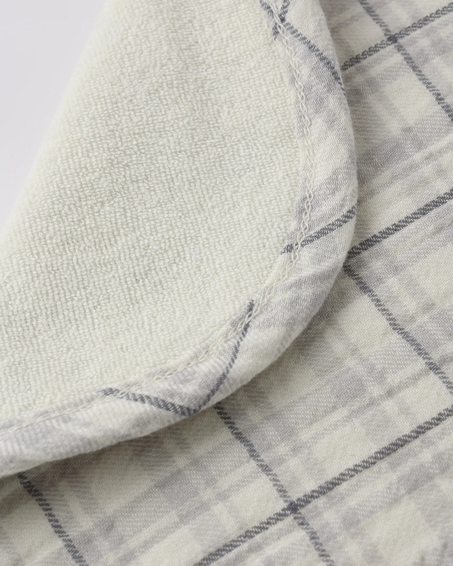 Blue plaid woven tie bib by Quincy Mae with soft fabric and adjustable neck strap for baby or toddler wear.