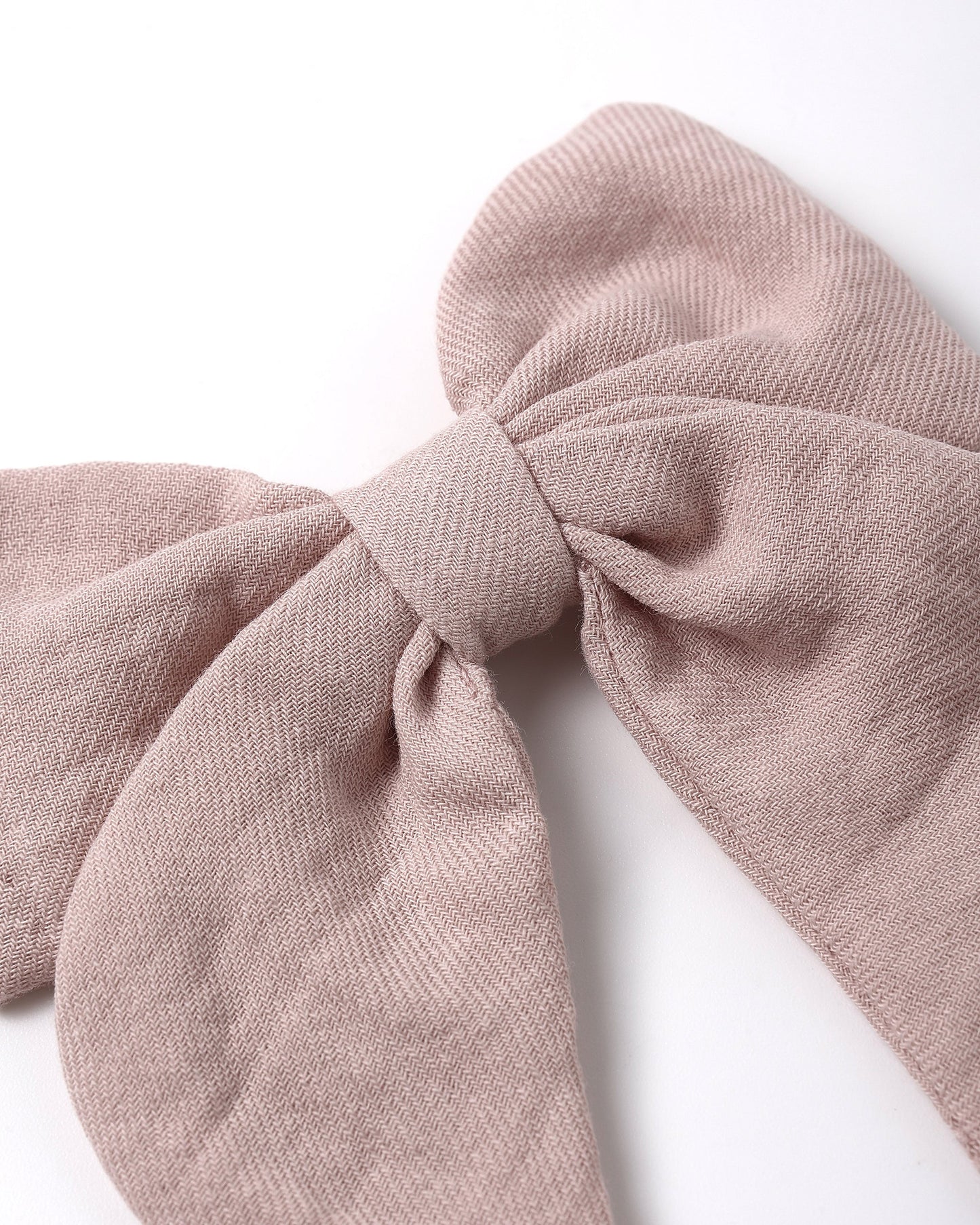Blush fabric bow hair accessory by Quincy Mae, featuring a soft pink color and delicate design for children or infants.