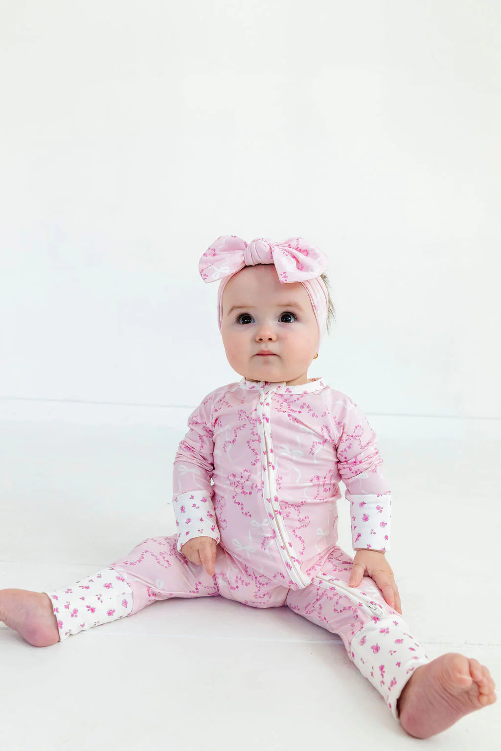 In My Jammers Cora Floral Zipper Romper featuring a vibrant floral pattern and front zipper detail, displayed on a hanger.