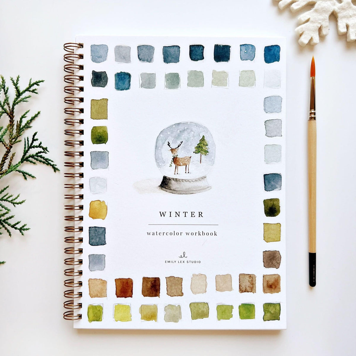 Watercolor workbook by Emily Lex Studio featuring colorful painted pages and practice sheets for artistic watercolor techniques.