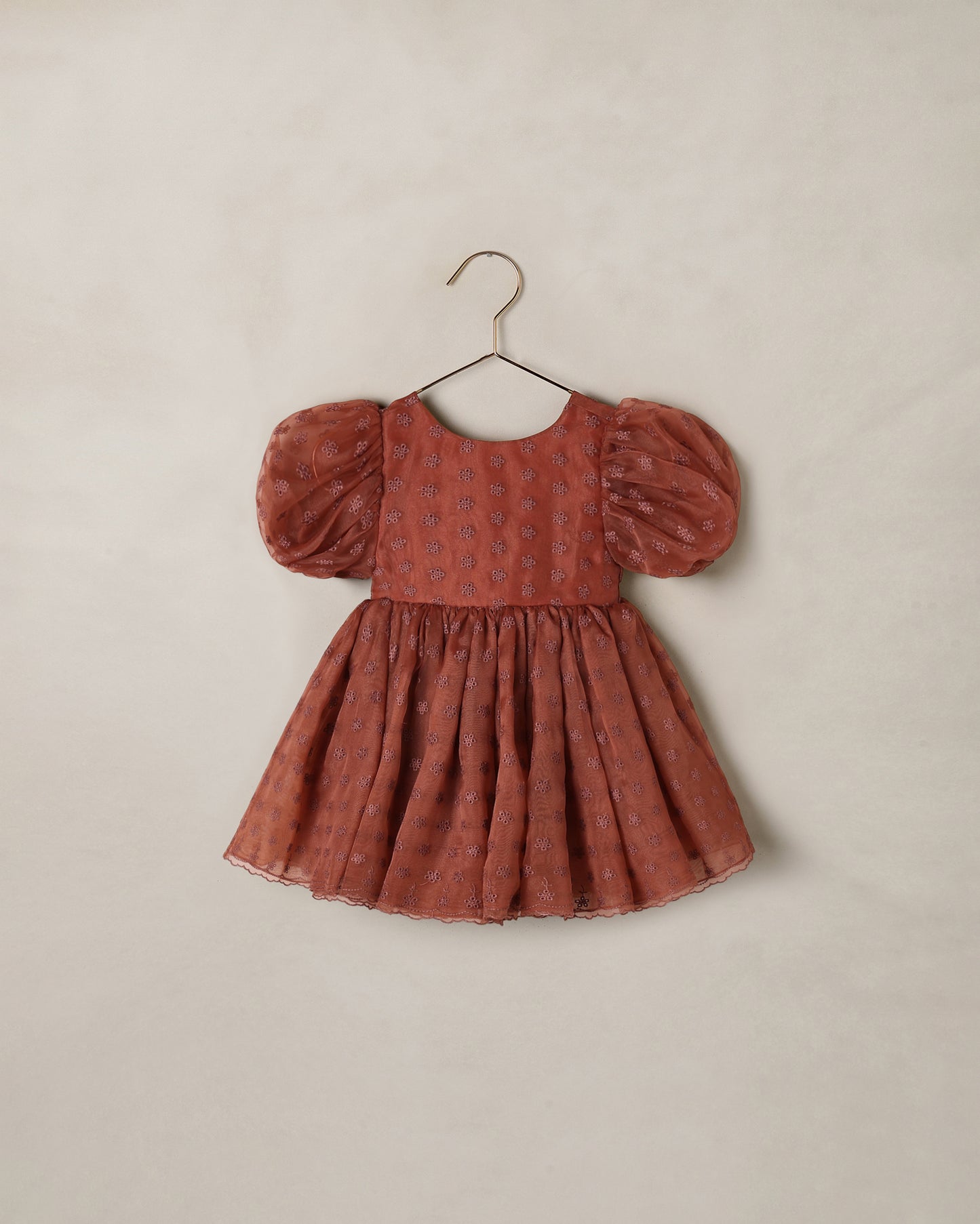 Noralee Spice Floral Sofia Dress displayed on a hanger, featuring vibrant floral patterns and lightweight fabric.