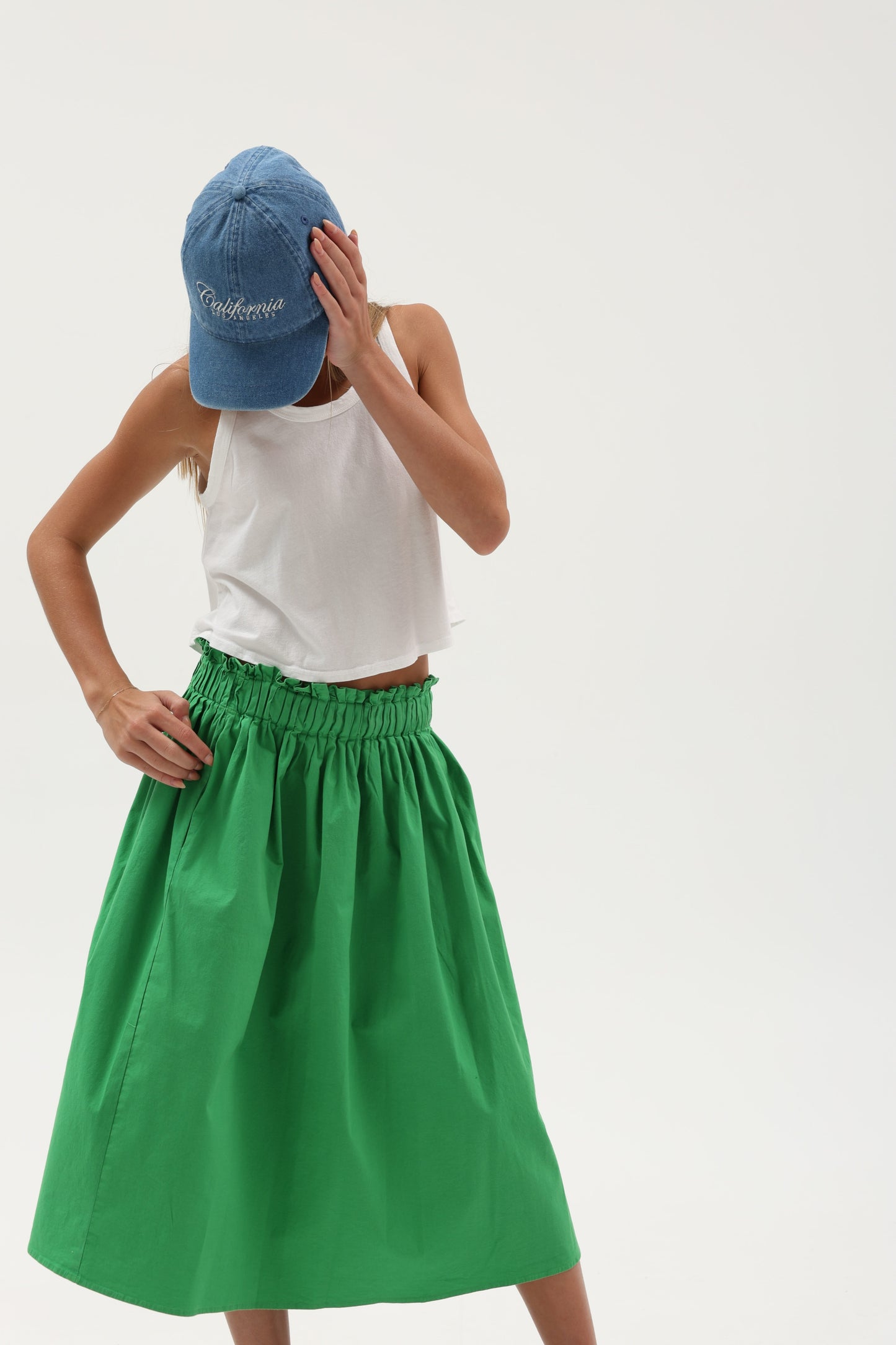 Seaweed print poplin midi skirt by TENLY featuring pintuck details and waist pockets, styled for a casual, elegant look.