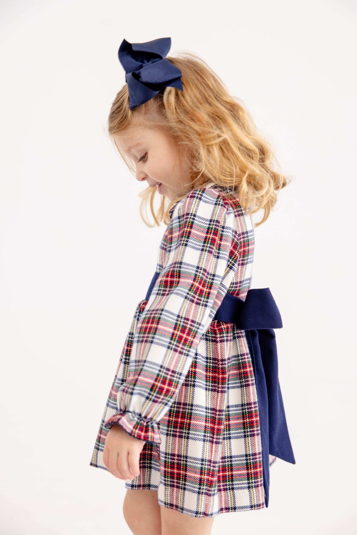 Long sleeve Cindy Lou sash dress in Paris Pike plaid and Nantucket Navy from The Beaufort Bonnet Company, displayed on a hanger.