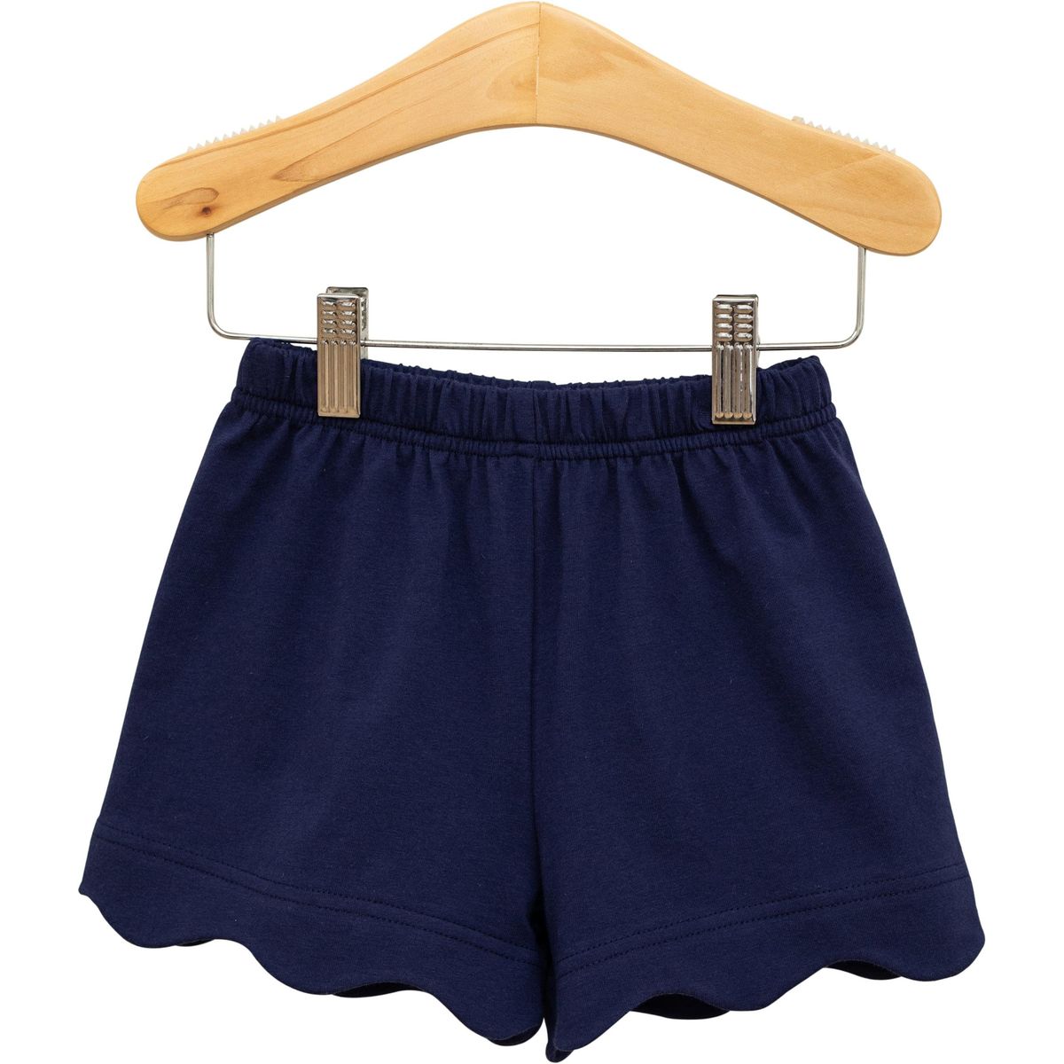 Navy scalloped shorts from Trotter Street displayed on a hanger with detailed scalloped hem and lightweight fabric.