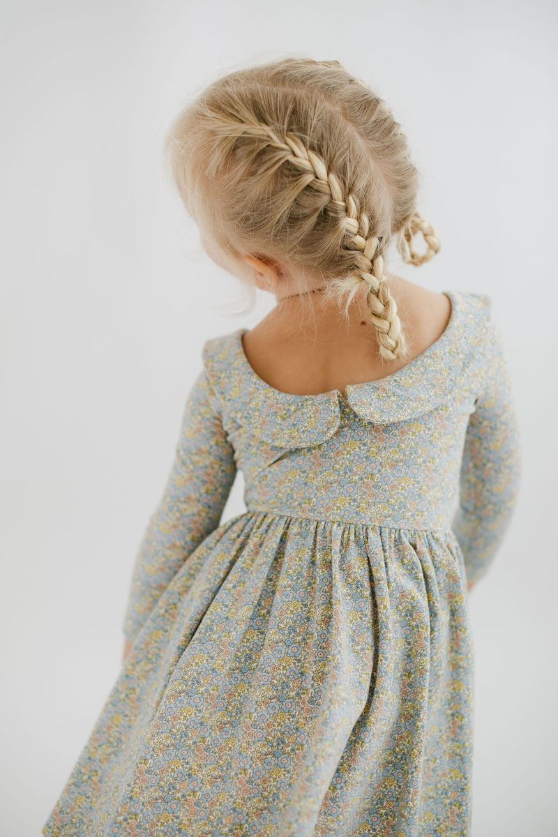 Blue watercolor floral twirl dress with 3/4 sleeves and collar by Good Apples, shown hanging on a white background.