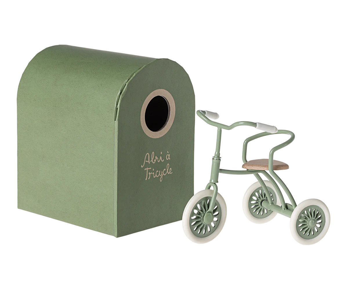 Maileg Green Mouse riding a tricycle, detailed fabric doll with a charming outfit and accessories, on a plain background.