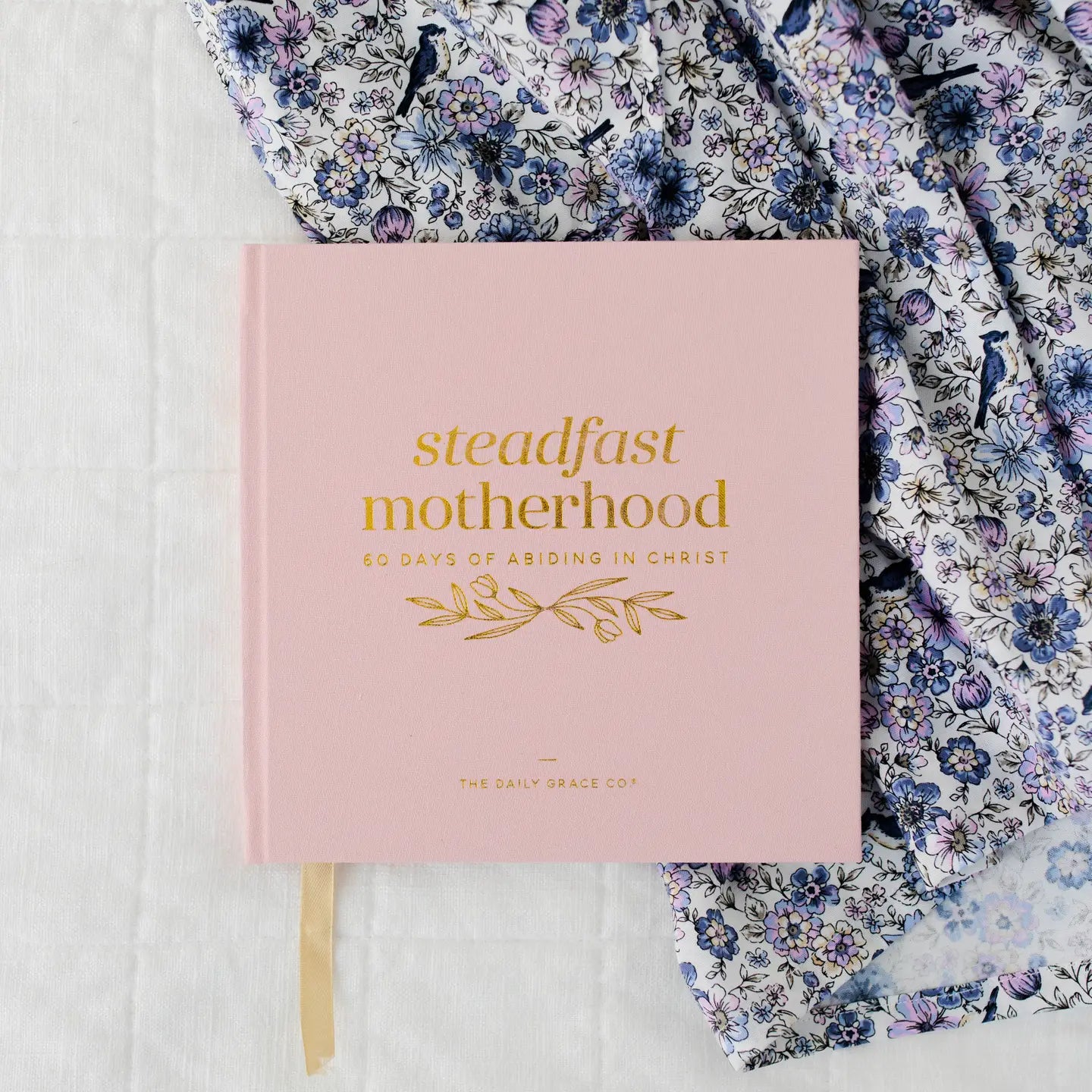 Open page of the Steadfast Motherhood Devotional by The Daily Grace Co with inspiring devotional quotes and illustrations.