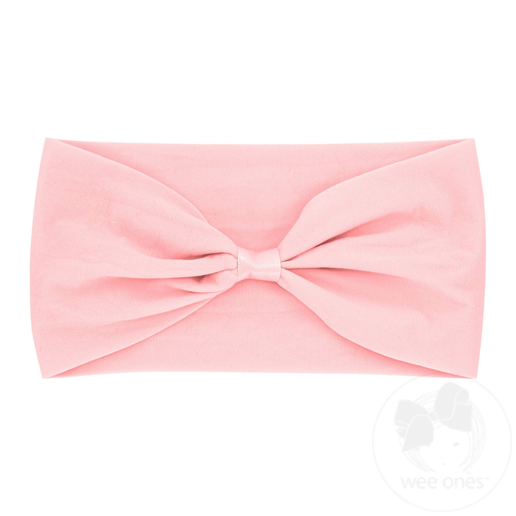 Light pink nylon baby headband with wrap and space to add a bow, from wee ones, shown on a baby head.