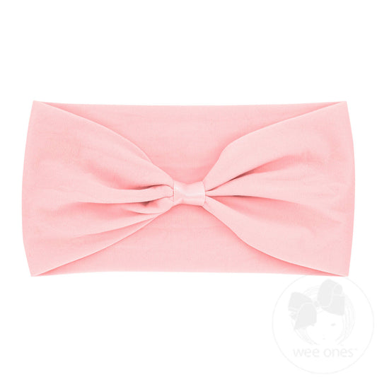 Light pink nylon baby headband with wrap and space to add a bow, from wee ones, shown on a baby head.