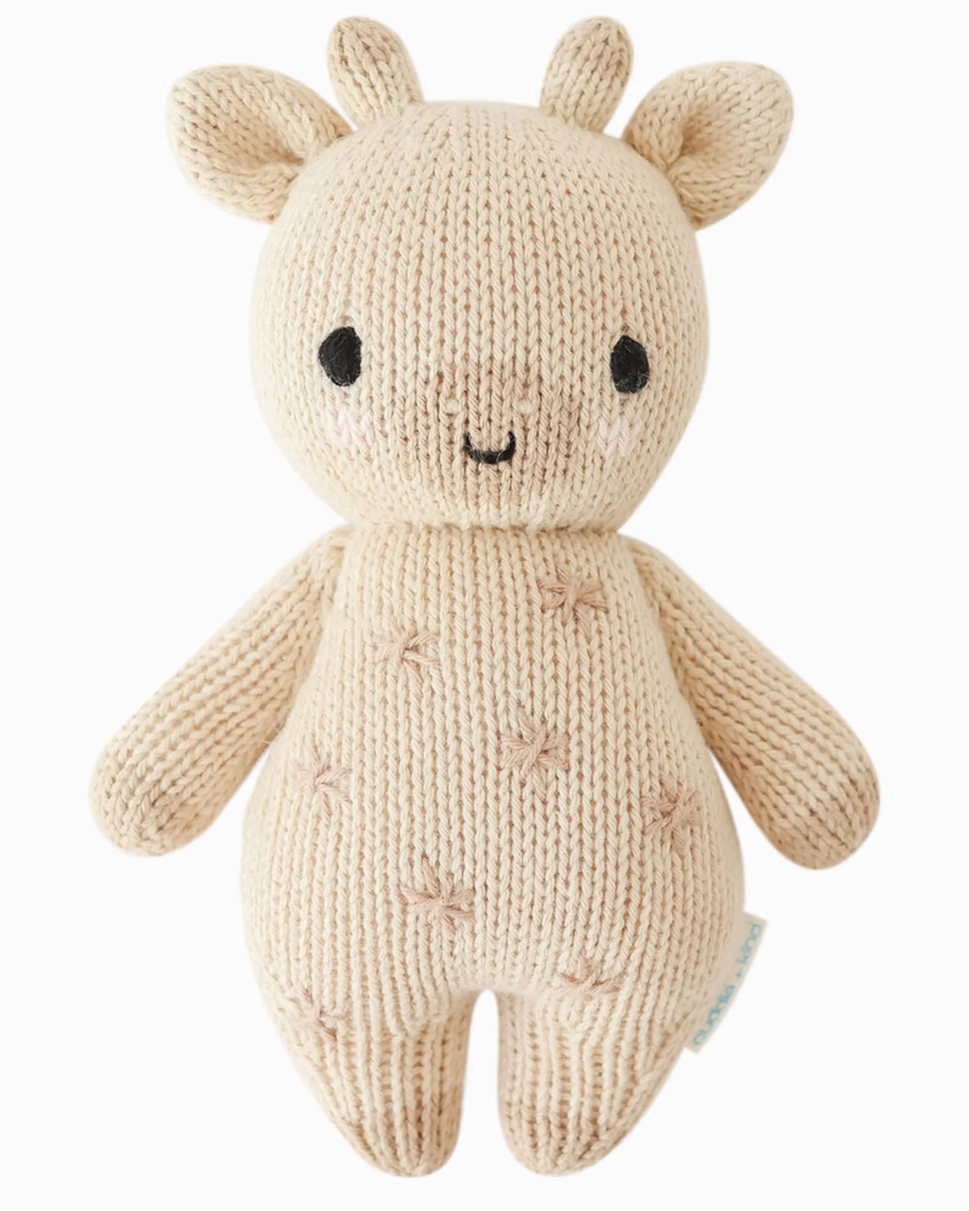 Soft plush baby giraffe toy by cuddle + kind, featuring gentle brown spots and a friendly face, perfect for cuddling and play.