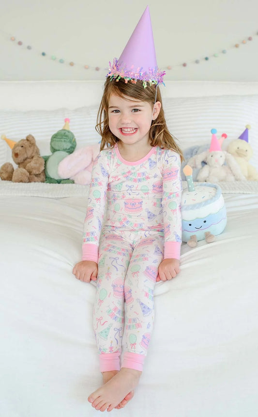 Pink birthday bash two-piece pajama set for girls by Caden Lane, featuring playful patterns and comfortable fabric.
