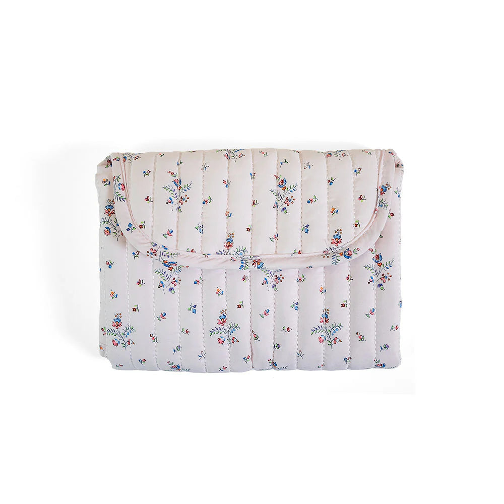 Soft quilted changing mat by TRVL Designs with padded surface and secure edges for comfortable diaper changes.