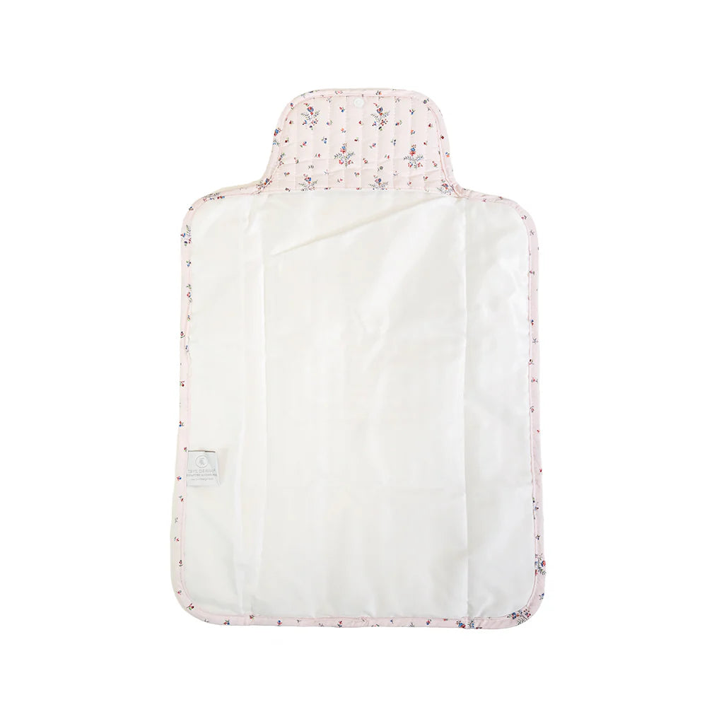 Quilted changing mat by TRVL Designs with soft padded surface and secure straps for comfortable baby diaper changes.