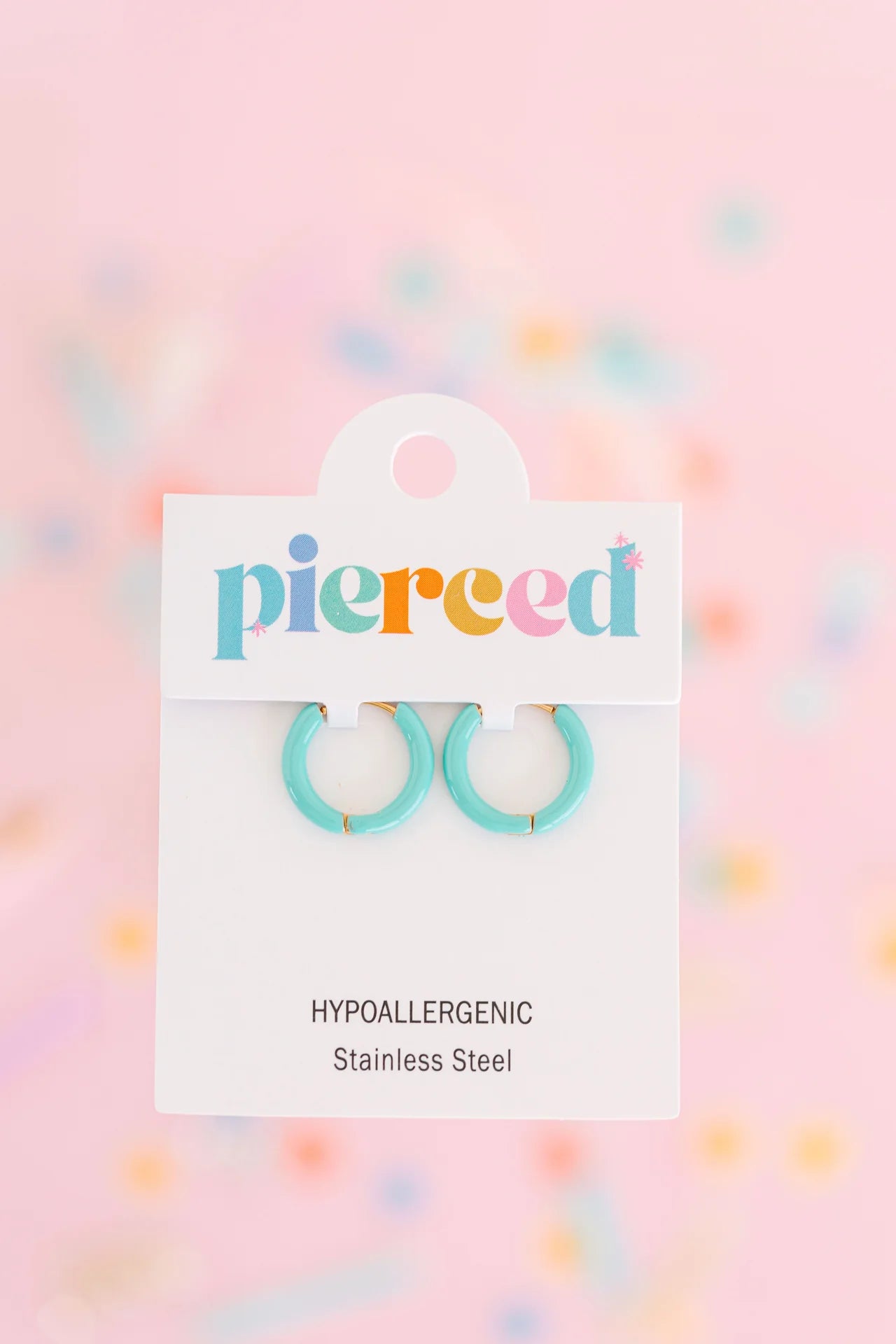 Pierced Co colored huggie earrings featuring vibrant, lightweight hoops with a smooth finish, suitable for pierced ears.
