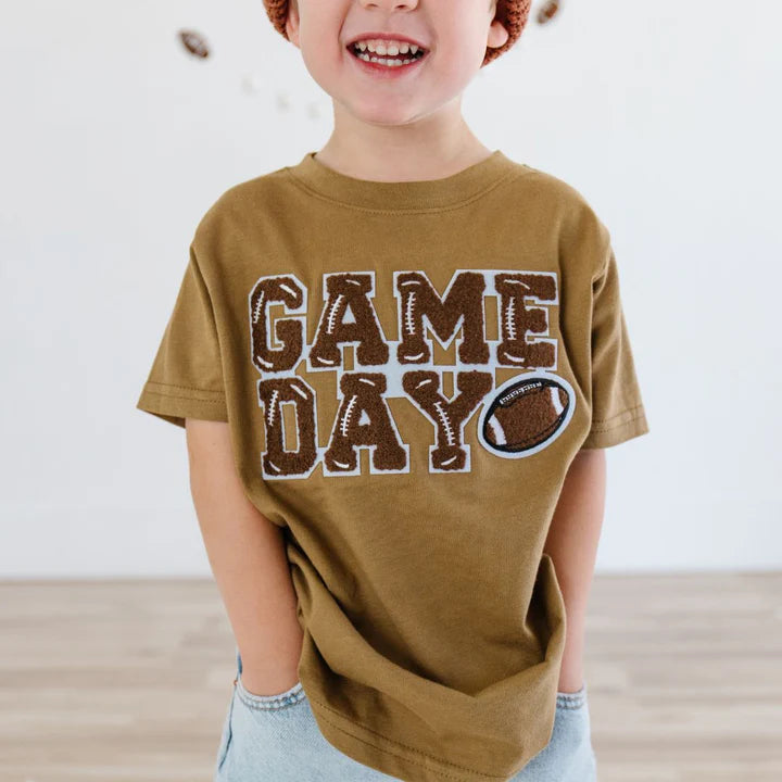 Model wearing Sweet Wink Game Day Patch short sleeve T-shirt in mocha with team patch detail.