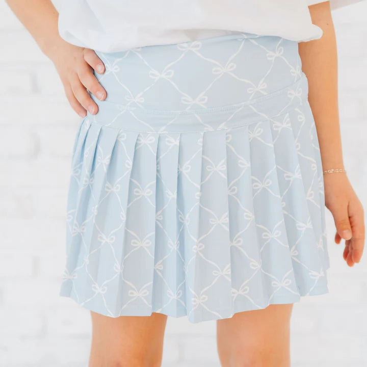 Sky blue athletic skort with bow and trellis pattern from Sweet Wink, worn by a model showcasing the sporty design and fit.