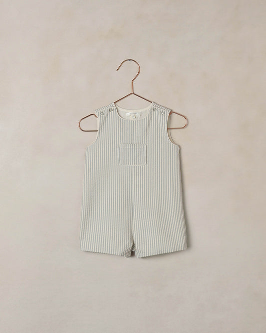 Noralee Sky Stripe Georgie Romper displayed on a hanger, featuring a playful sky blue and white striped pattern and soft fabric.