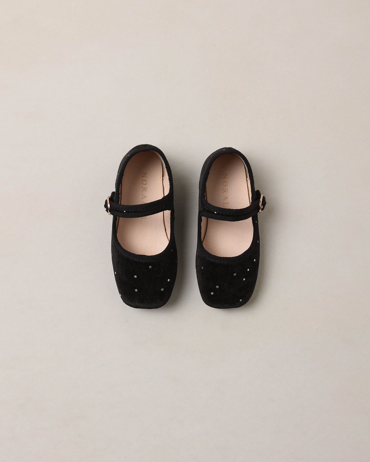 Black strap ballet flats by Noralee featuring a sleek design and comfortable fit, perfect for casual or dressy occasions.