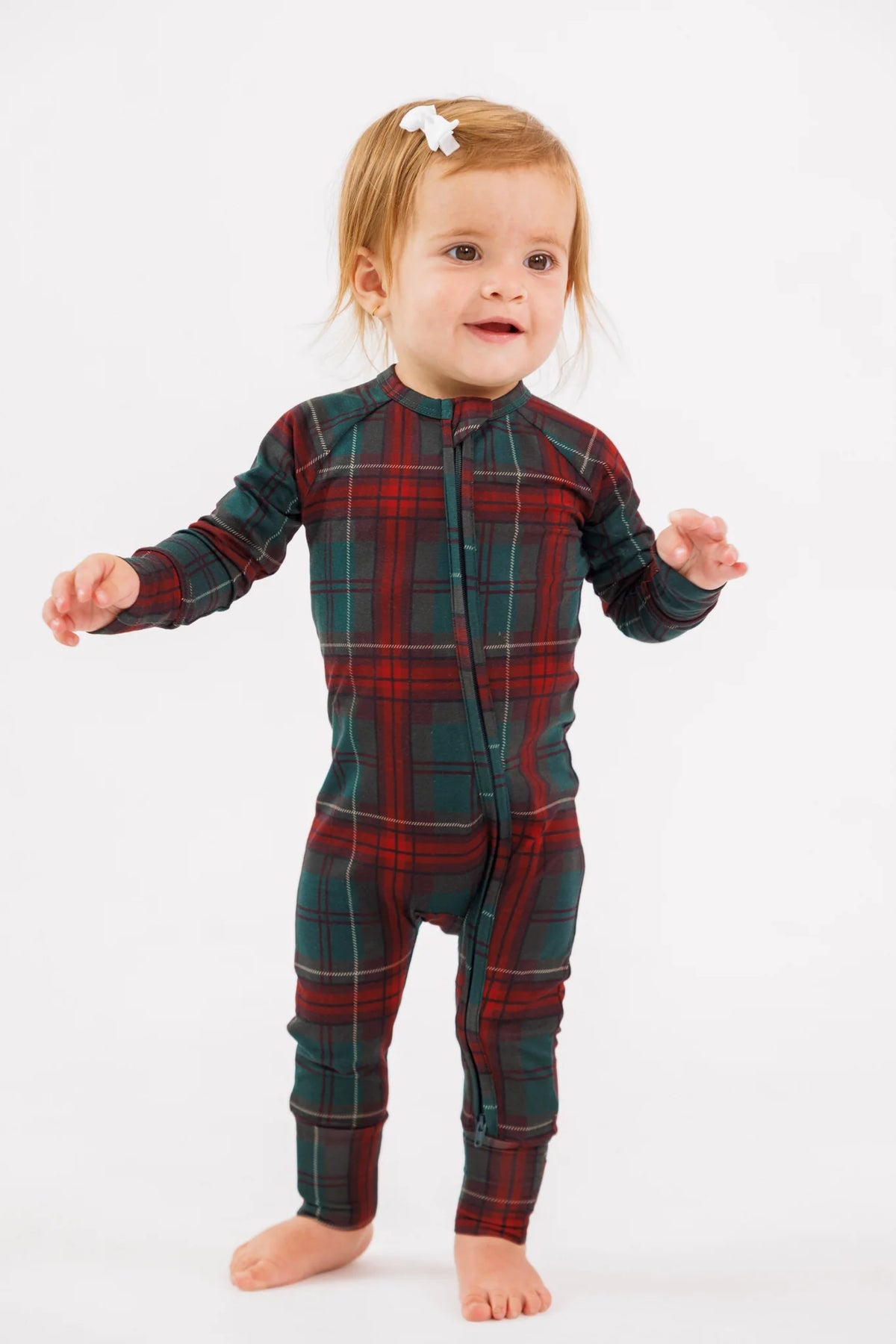 In My Jammers Holiday Heritage plaid zipper romper, featuring festive red and green plaid fabric with a front zipper and long sleeves.
