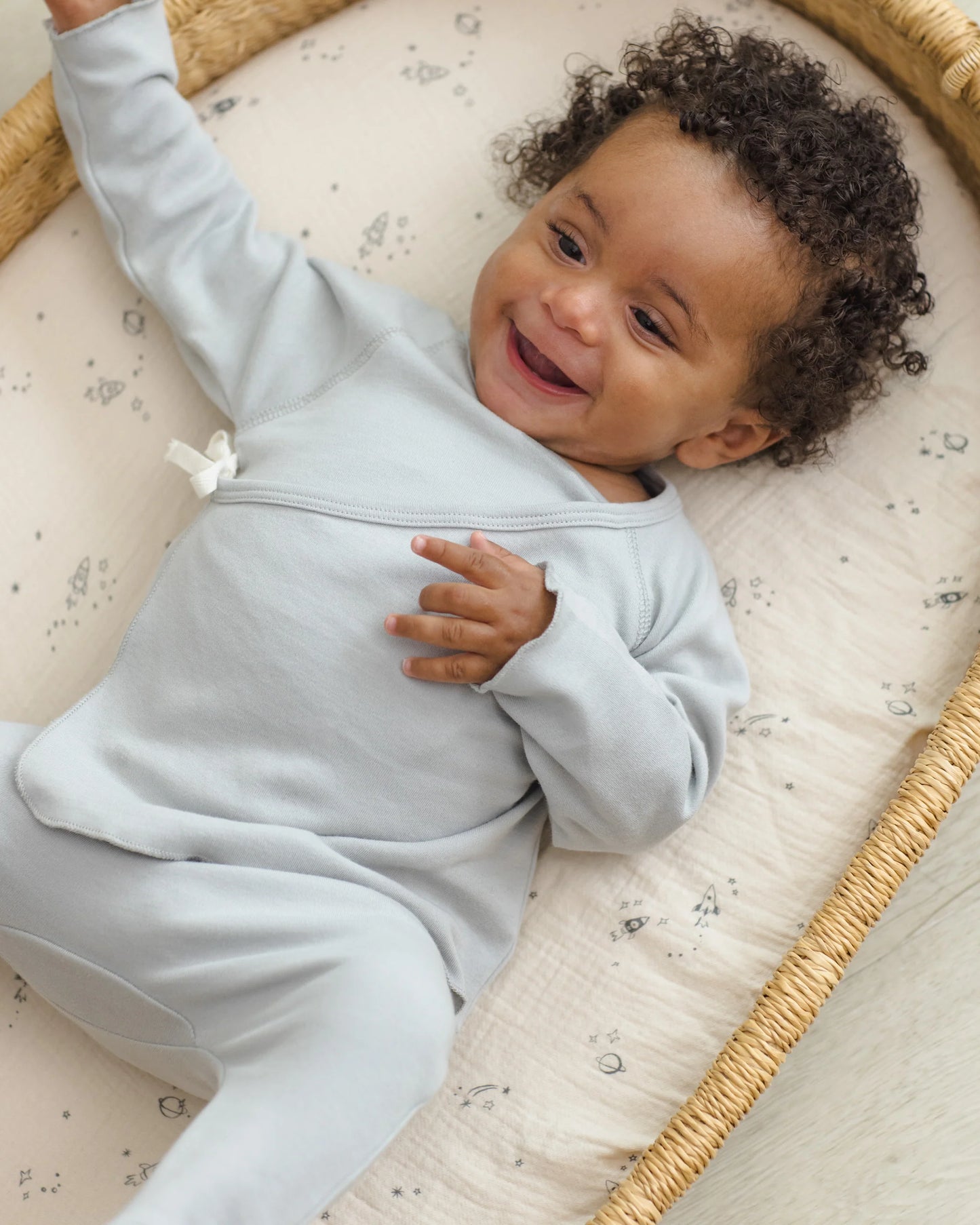 Quincy Mae Sky Wrap Top and Footed Pant set in soft fabric, shown on a child in a cozy, casual lifestyle setting.