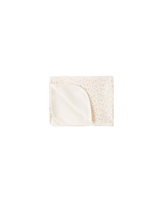 Cream-colored Ditsy Swaddle by Quincy Mae featuring a delicate floral pattern, soft and breathable fabric for newborn comfort.