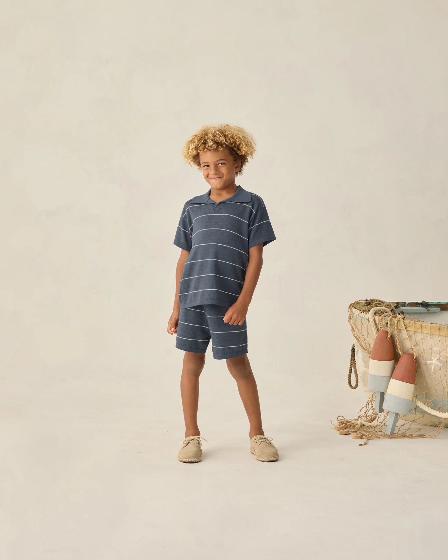 Navy and white striped Chandler Knit Polo by Rylee & Cru, featuring a classic collar and short sleeves, laid flat on a white background.