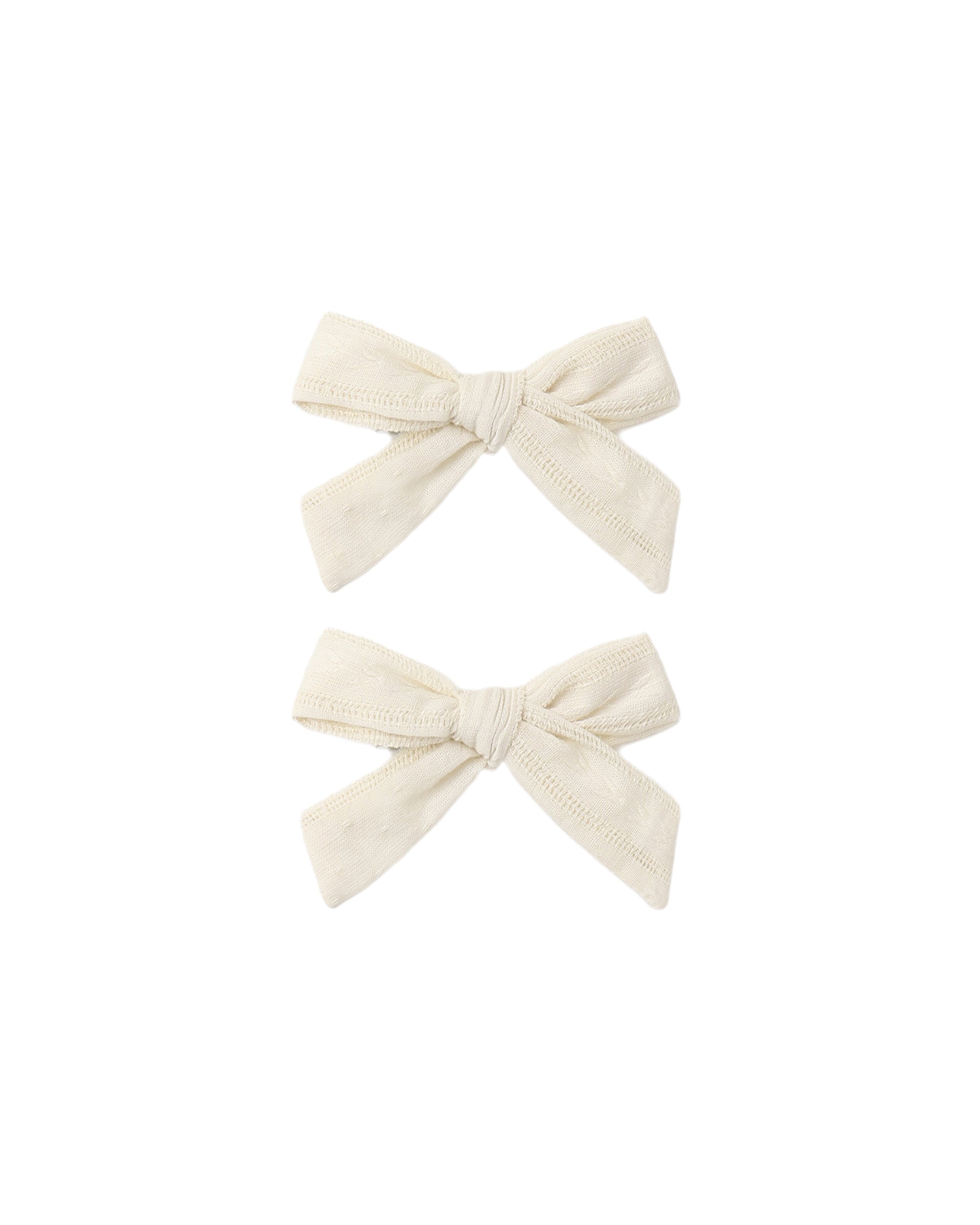 Set of two natural-colored fabric bows by Rylee & Cru, perfect for baby girl accessories or hair embellishments.