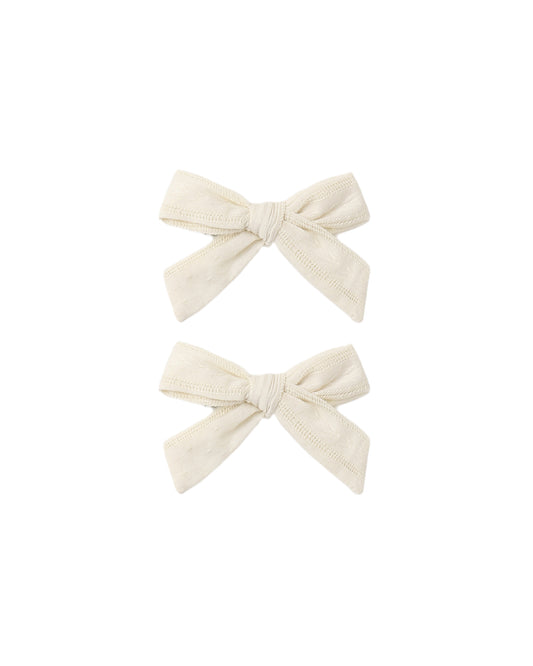 Set of two natural-colored fabric bows by Rylee & Cru, perfect for baby girl accessories or hair embellishments.