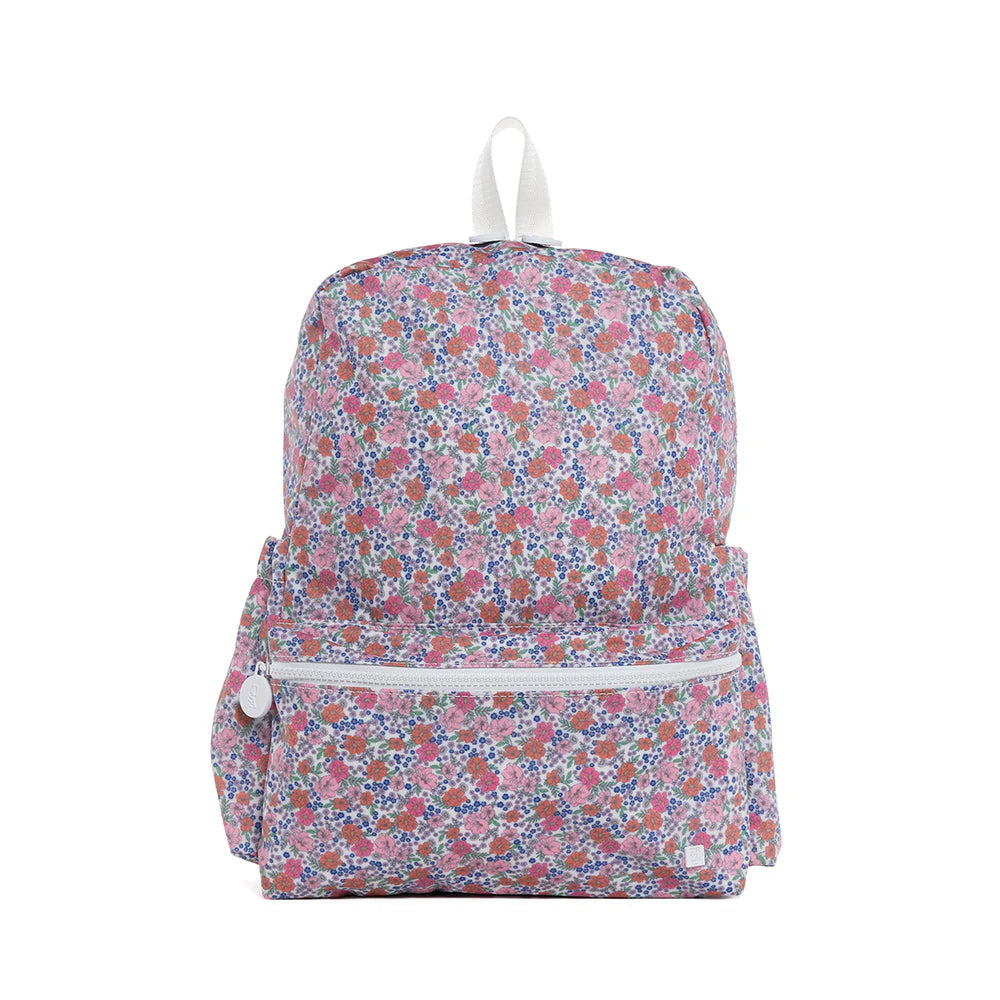 TRVL Designs TSA backpack featuring a floral garden pattern, sturdy straps, and multiple compartments for travel and everyday use.