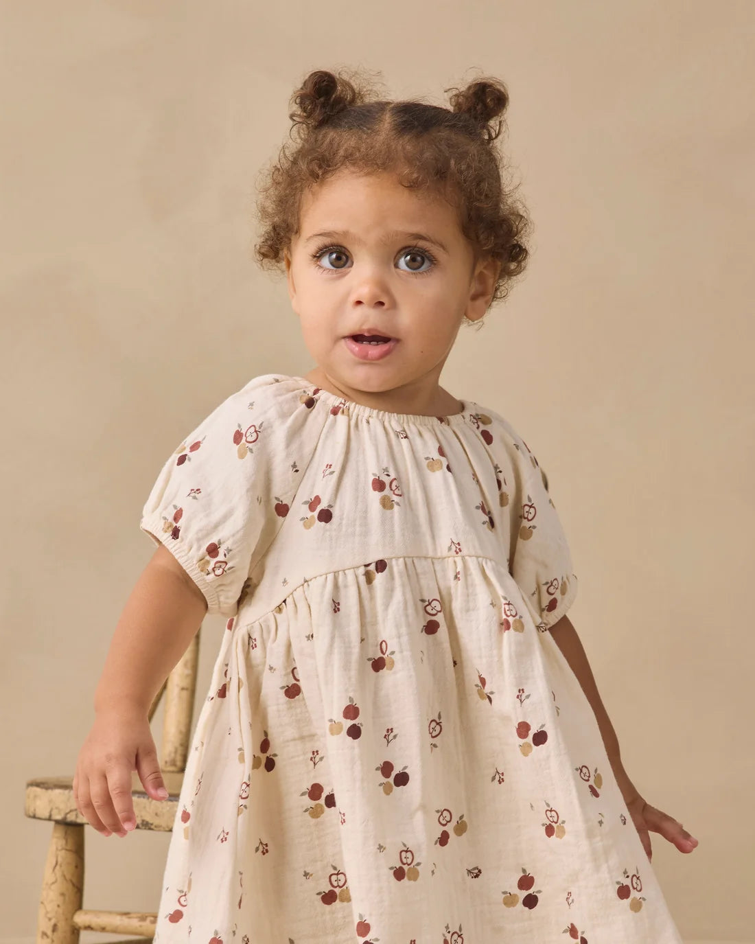 Quincy Mae Apples Bella Dress in soft fabric with apple pattern, front view showing neckline and shoulder details.