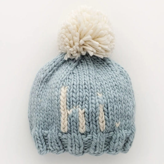 Huggalugs blue hand-knit beanie hat with a cozy, textured design, perfect for warmth and style in cold weather.