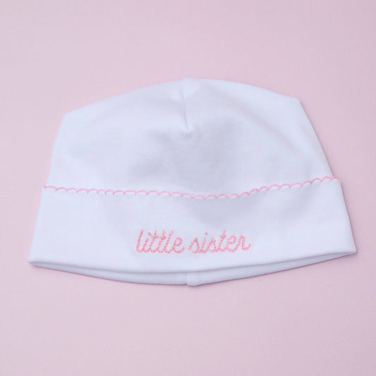 Magnolia Baby Little Sister embroidered hat in soft fabric with pink embroidery, designed for infants and toddlers.