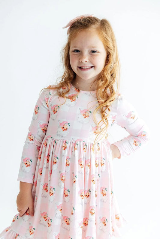 Mila & Rose Storybook Santa long-sleeve twirl dress with ruffle hem, featuring festive holiday print and soft cotton fabric for girls.
