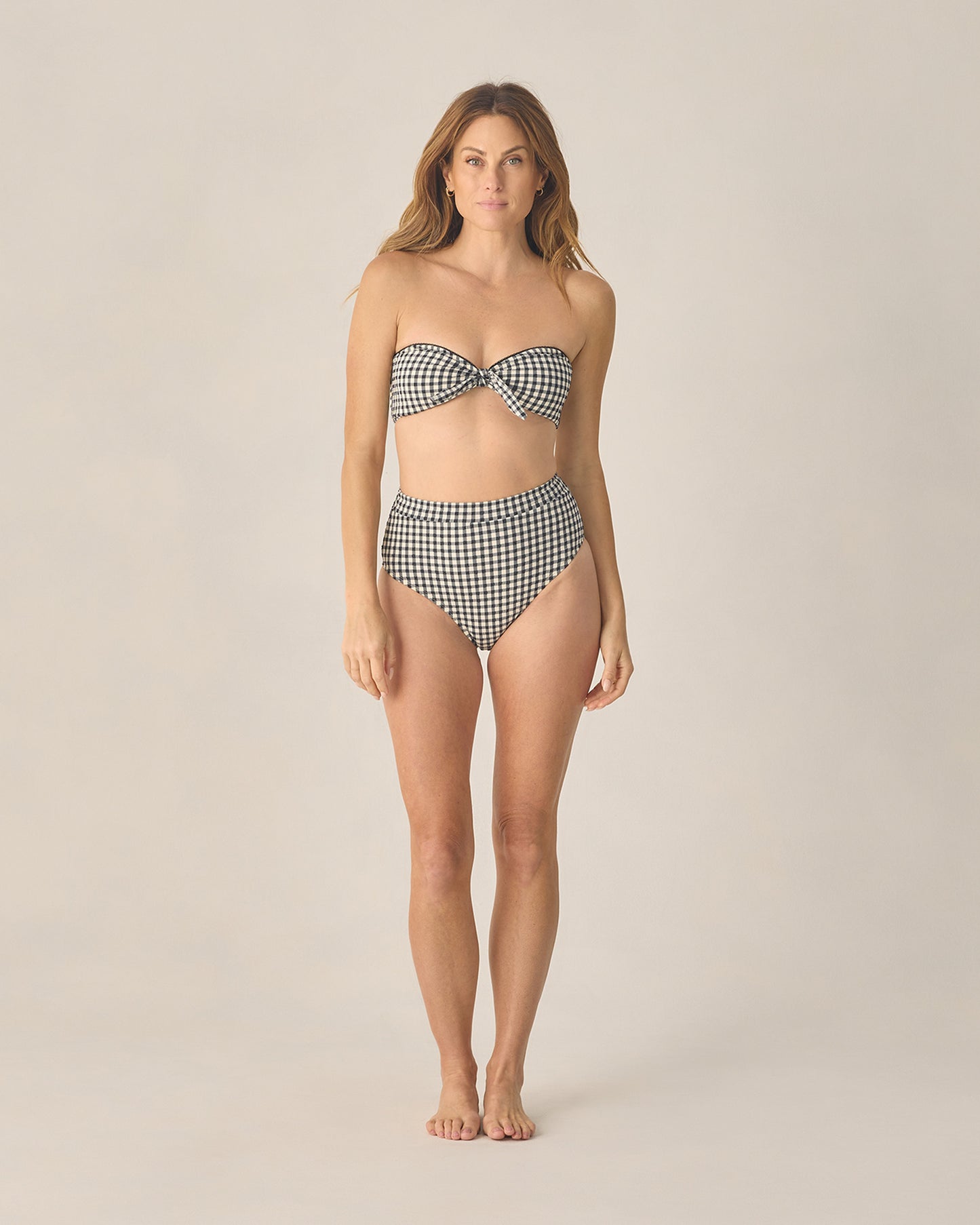 Women's black gingham bandeau bikini top with knotted front by Rylee & Cru, shown on a model.