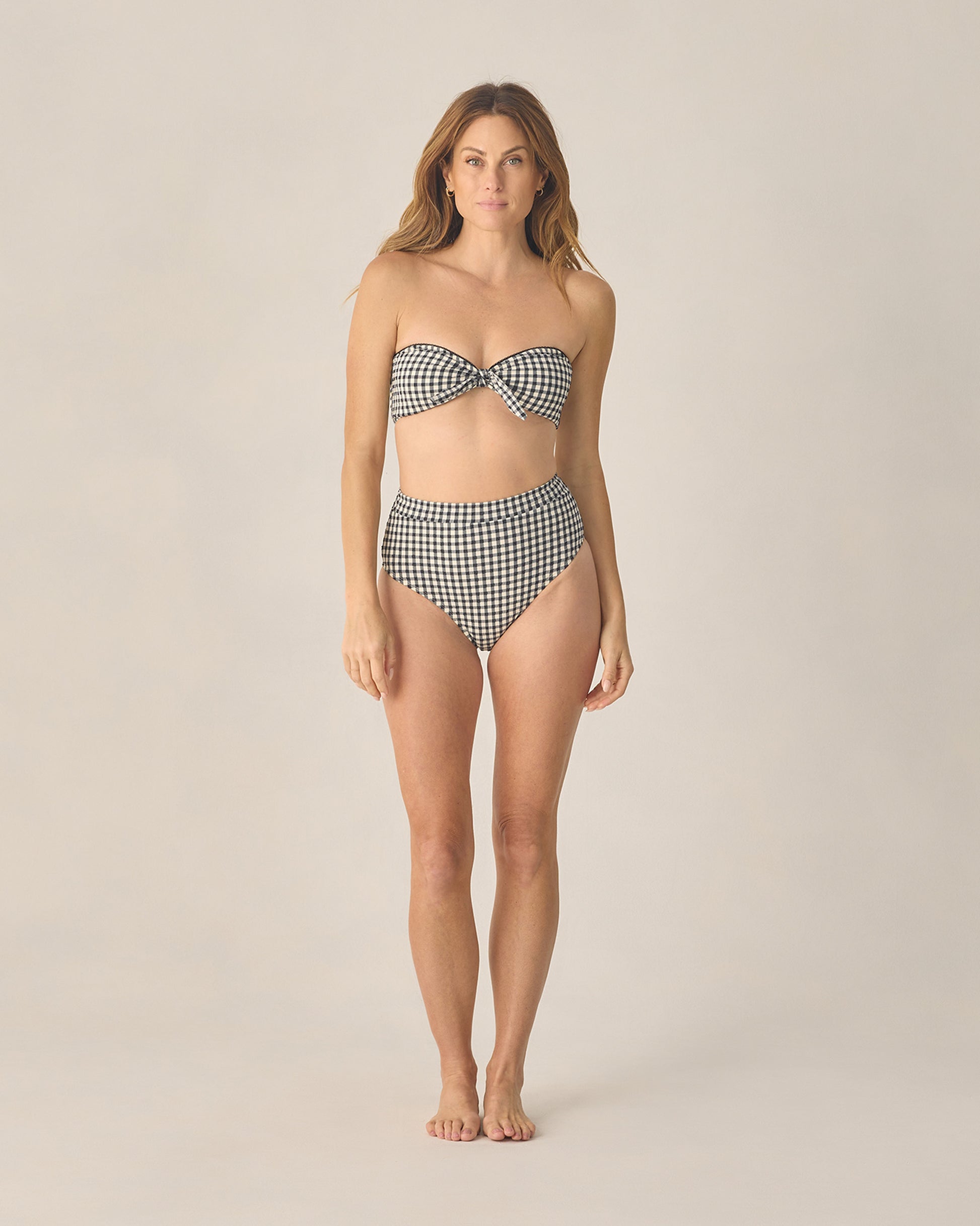 Women's black gingham bandeau bikini top with knotted front by Rylee & Cru, shown on a model.
