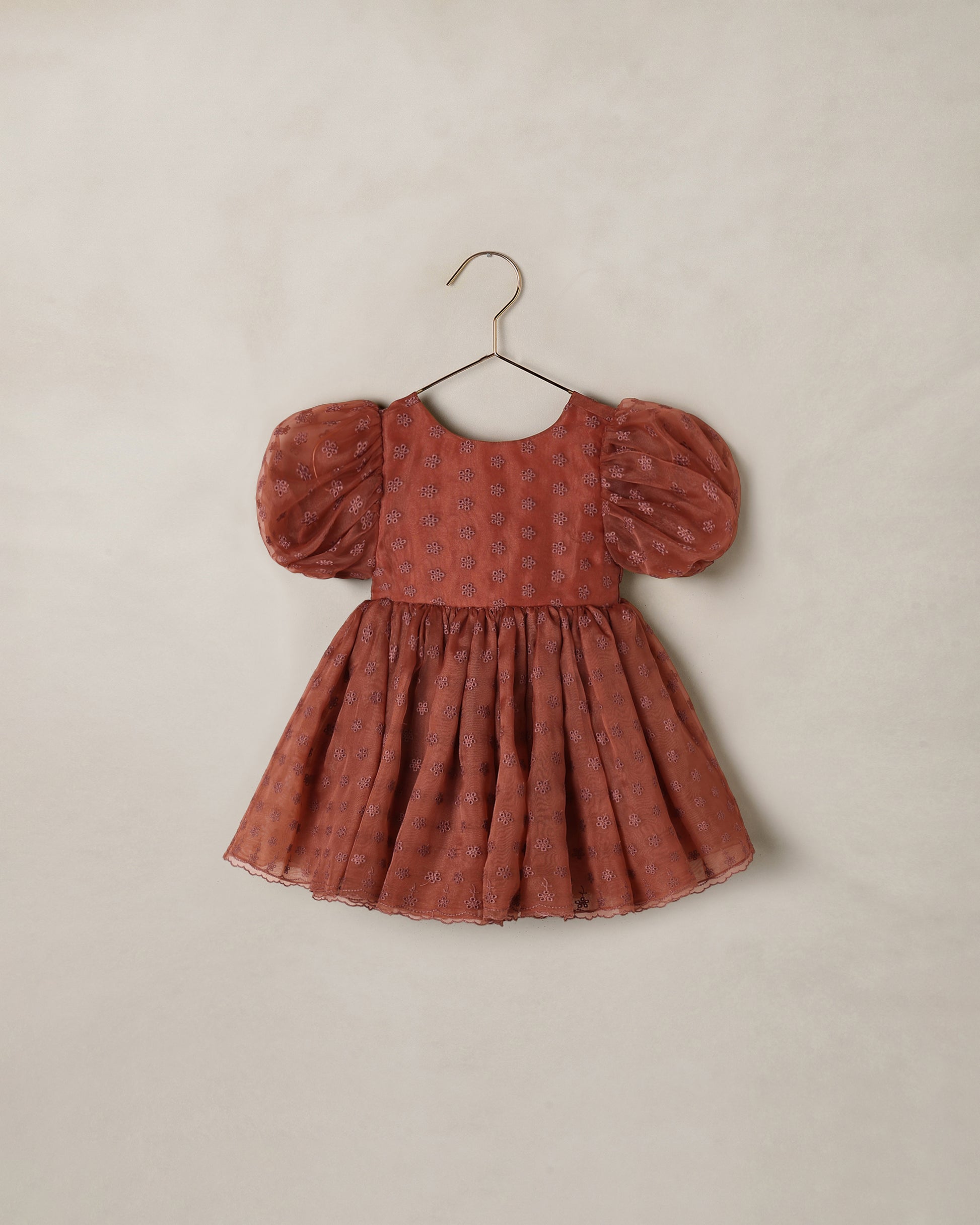 Noralee Spice Floral Sofia Dress displayed on a hanger, featuring vibrant floral patterns and lightweight fabric.