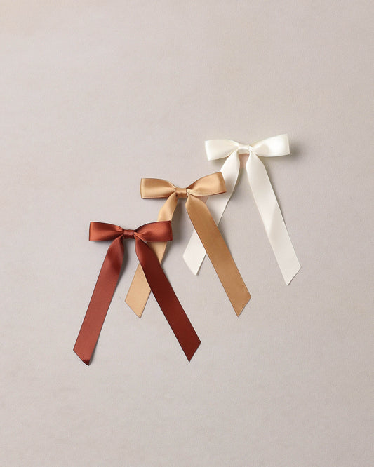 Ivory and gold Noralee spice ribbon bows with elegant, decorative design for gift wrapping or craft projects.