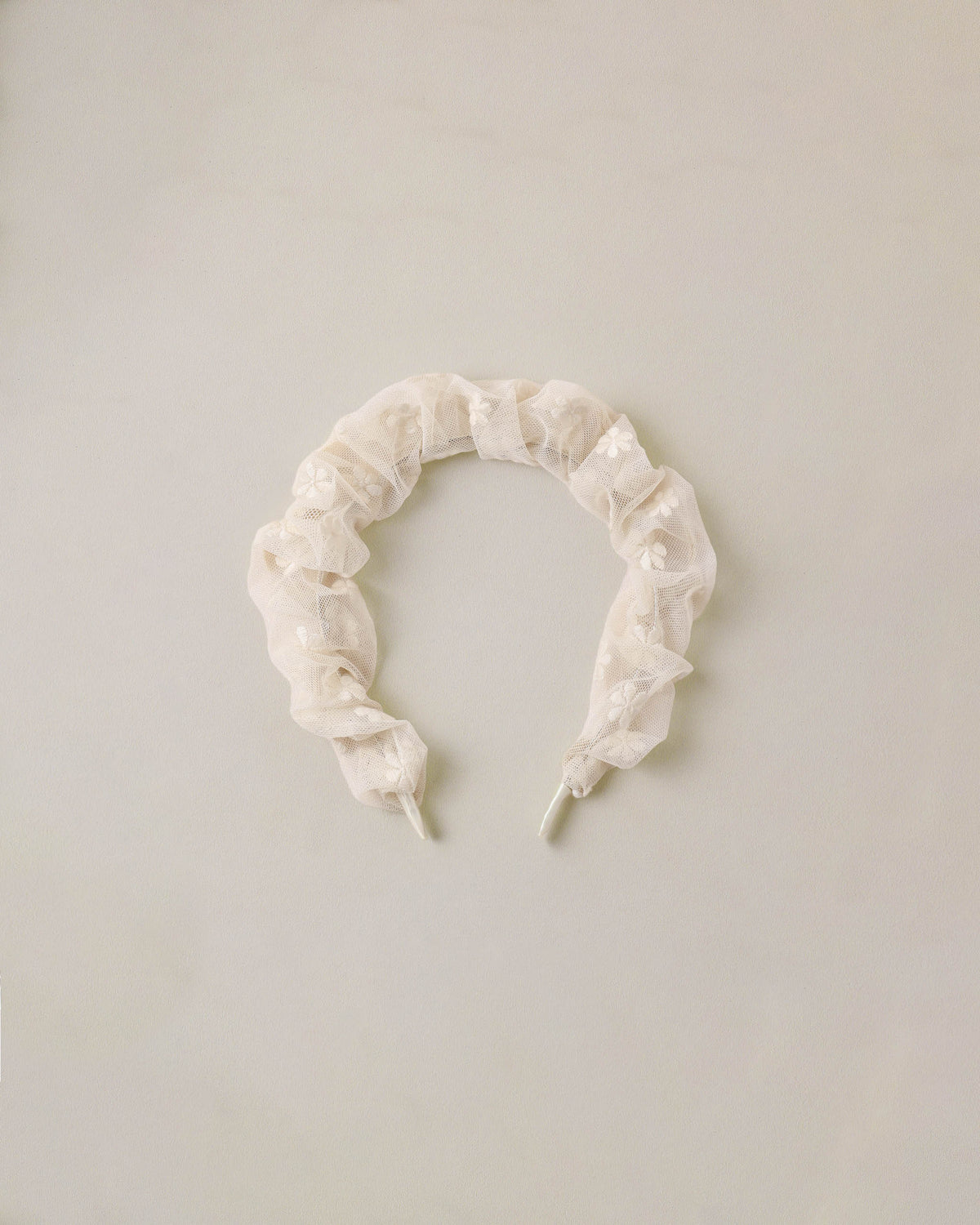 Noralee embroidered daisy gathered headband with floral design, featuring intricate embroidery and soft fabric for a stylish accessory.