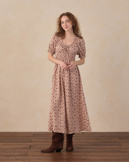 Women's pink floral Haisley dress by Rylee & Cru, featuring a flowy fabric and vibrant floral pattern on a sunny background.