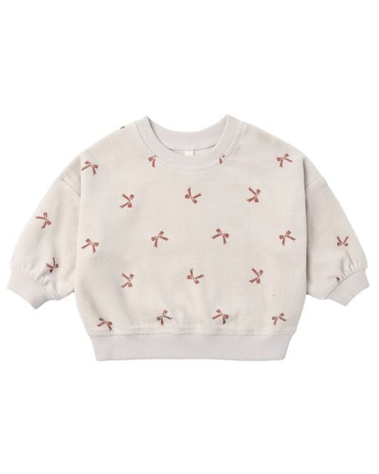 Red velour sweatshirt with bow details from Quincy Mae, relaxed fit, soft fabric, shown on a hanger.