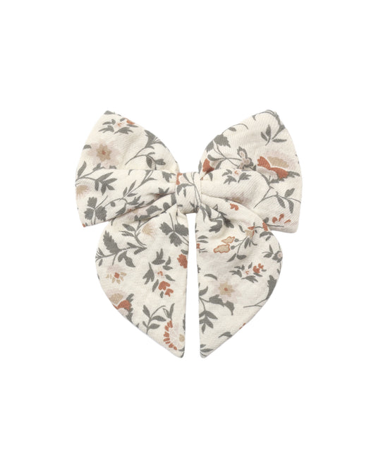 Holiday floral bow by Quincy Mae featuring festive red and green fabric with floral accents, perfect for holiday decorating.