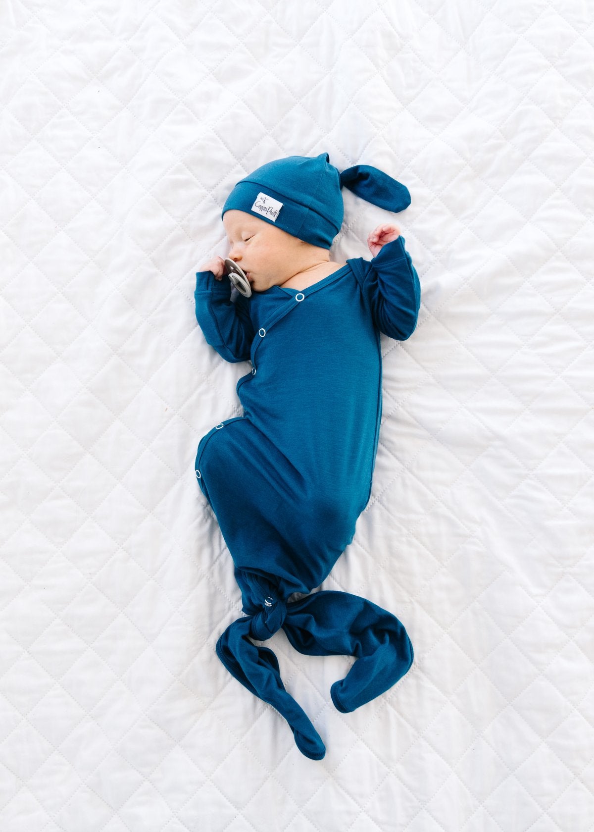 Copper Pearl newborn knotted gown in river color, soft cotton fabric with a relaxed fit and gentle knot design for infants.