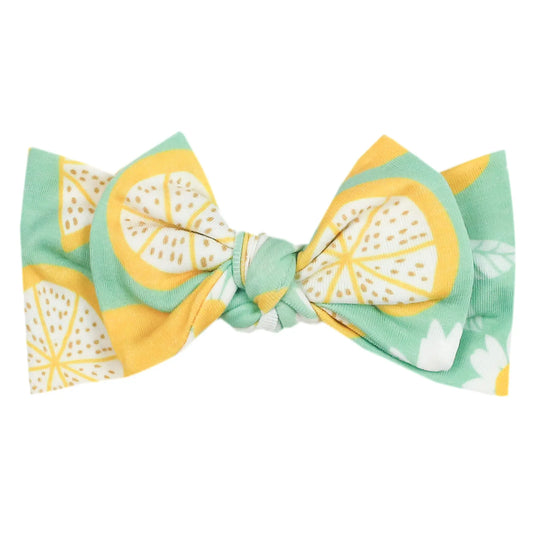 Copper Pearl Lemon headband with a bow, soft and stretchy fabric, perfect for babies and toddlers.